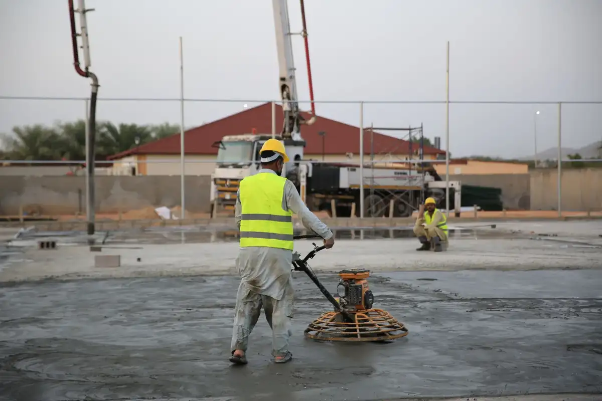 Construction workers coordinating around heavy equipment on site